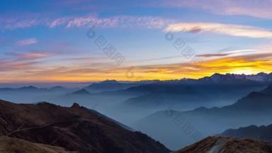 日落时阿尔卑斯山的全景。绚丽的天空, 高山的山峰, 山谷里的雾气.